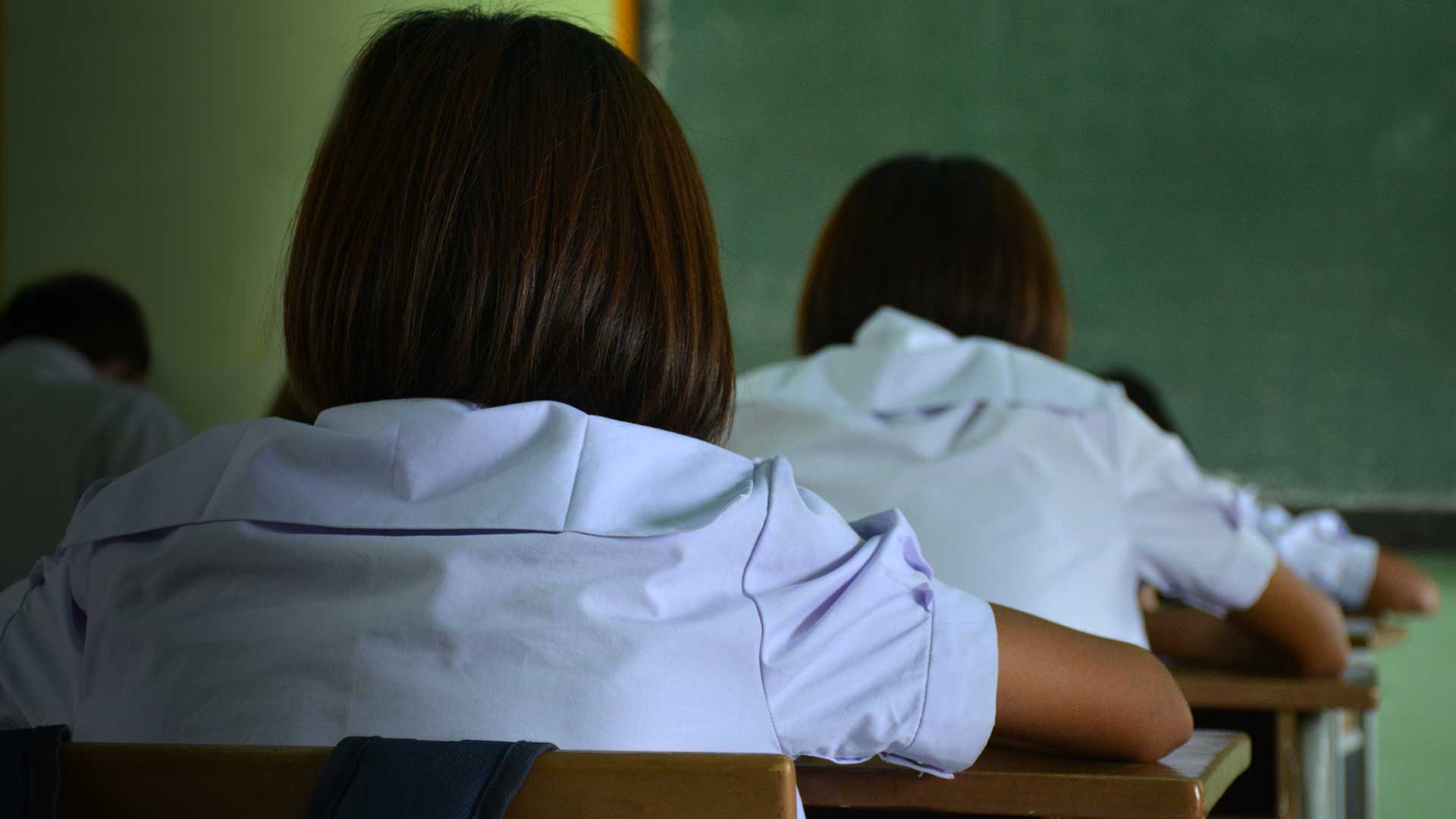 Estudantes realizando avaliação em sala de aula, uma das ações estruturantes ao combate do analfabetismo funcional.